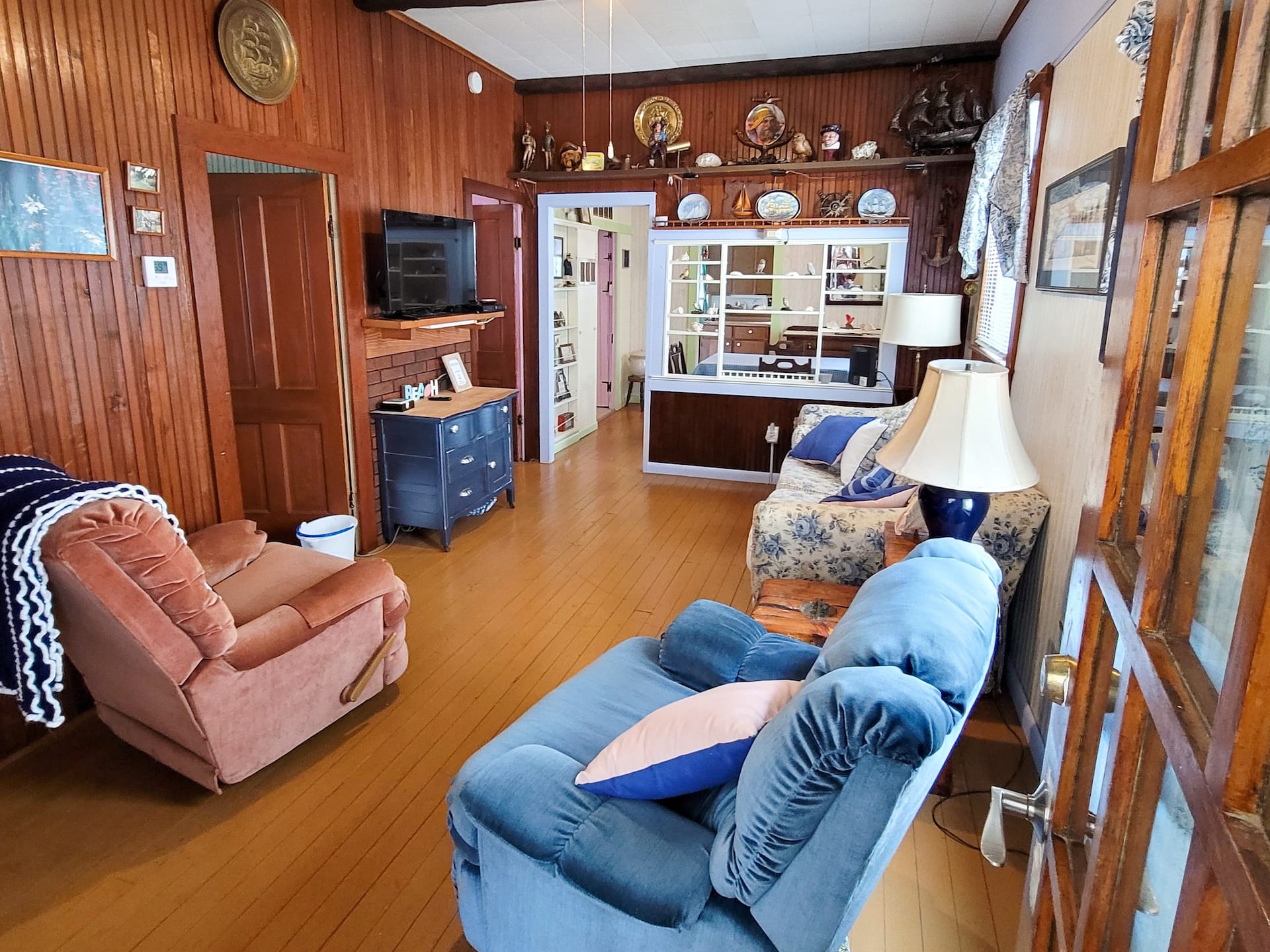 Wood-panelled sitting area with a blue sofa and a recliner