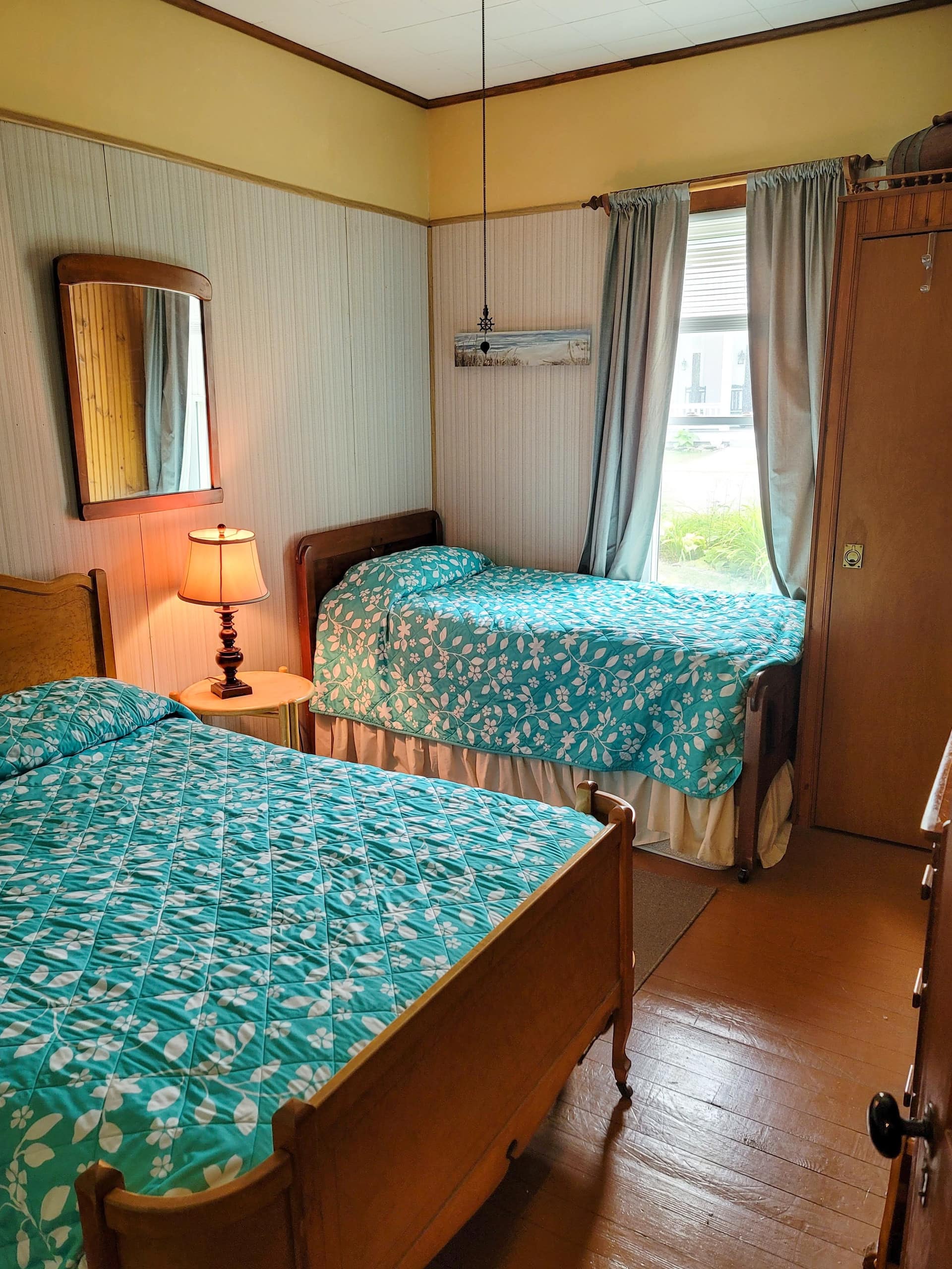Bedroom with two beds under teal coverlets