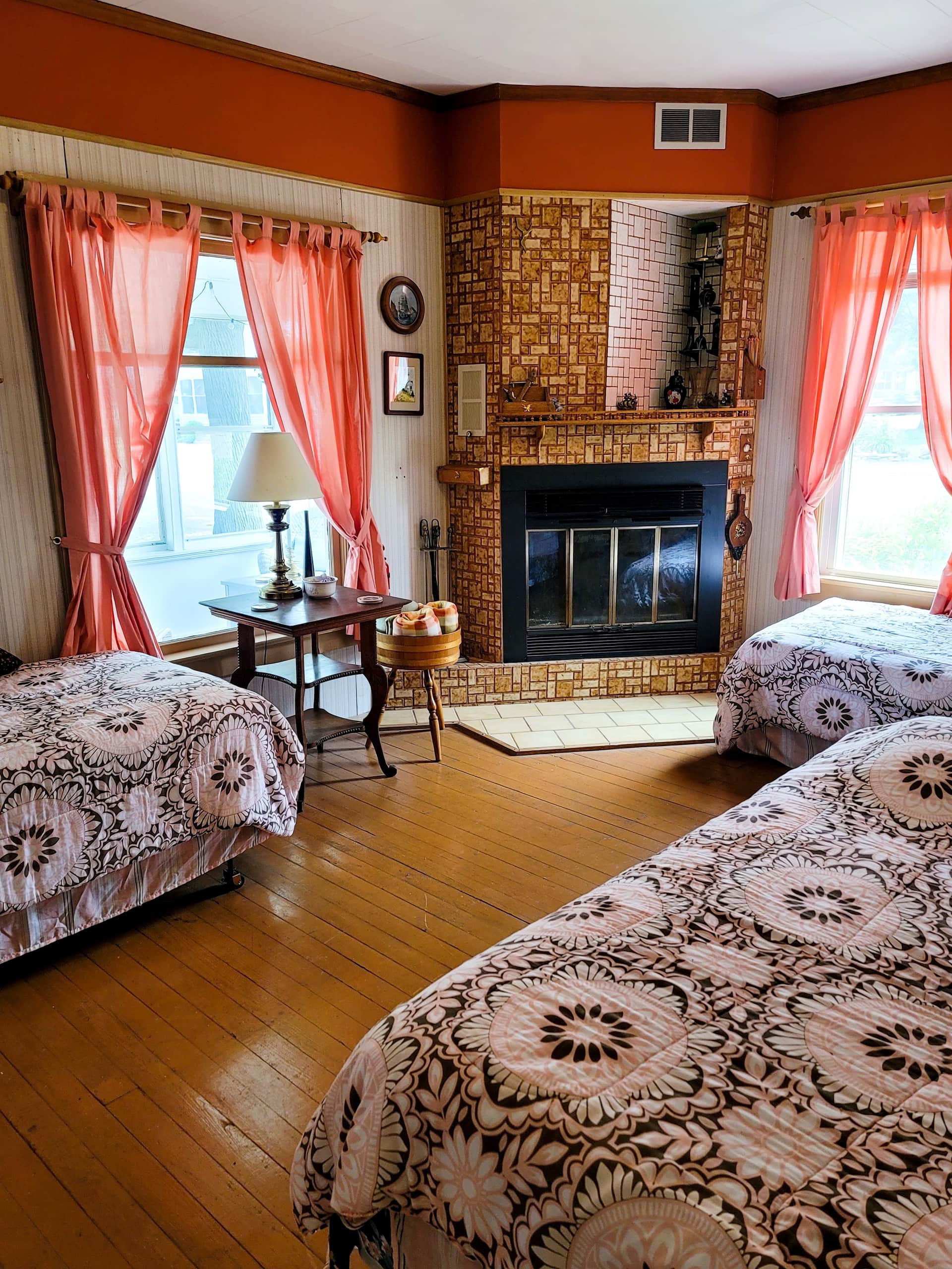 Bedroom with two beds and a tiled fireplace