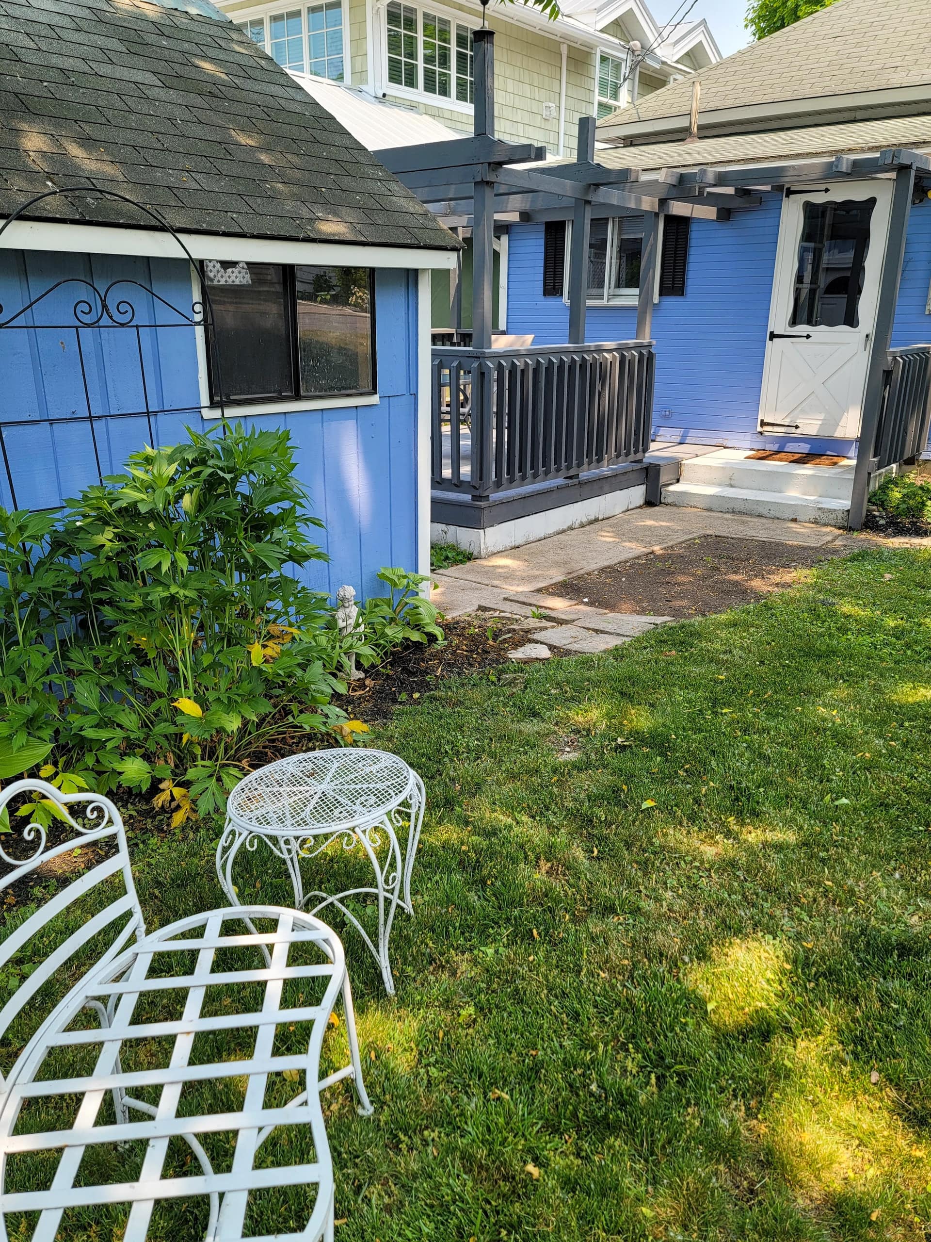 Metal garden chairs on the lawn behind the cottage
