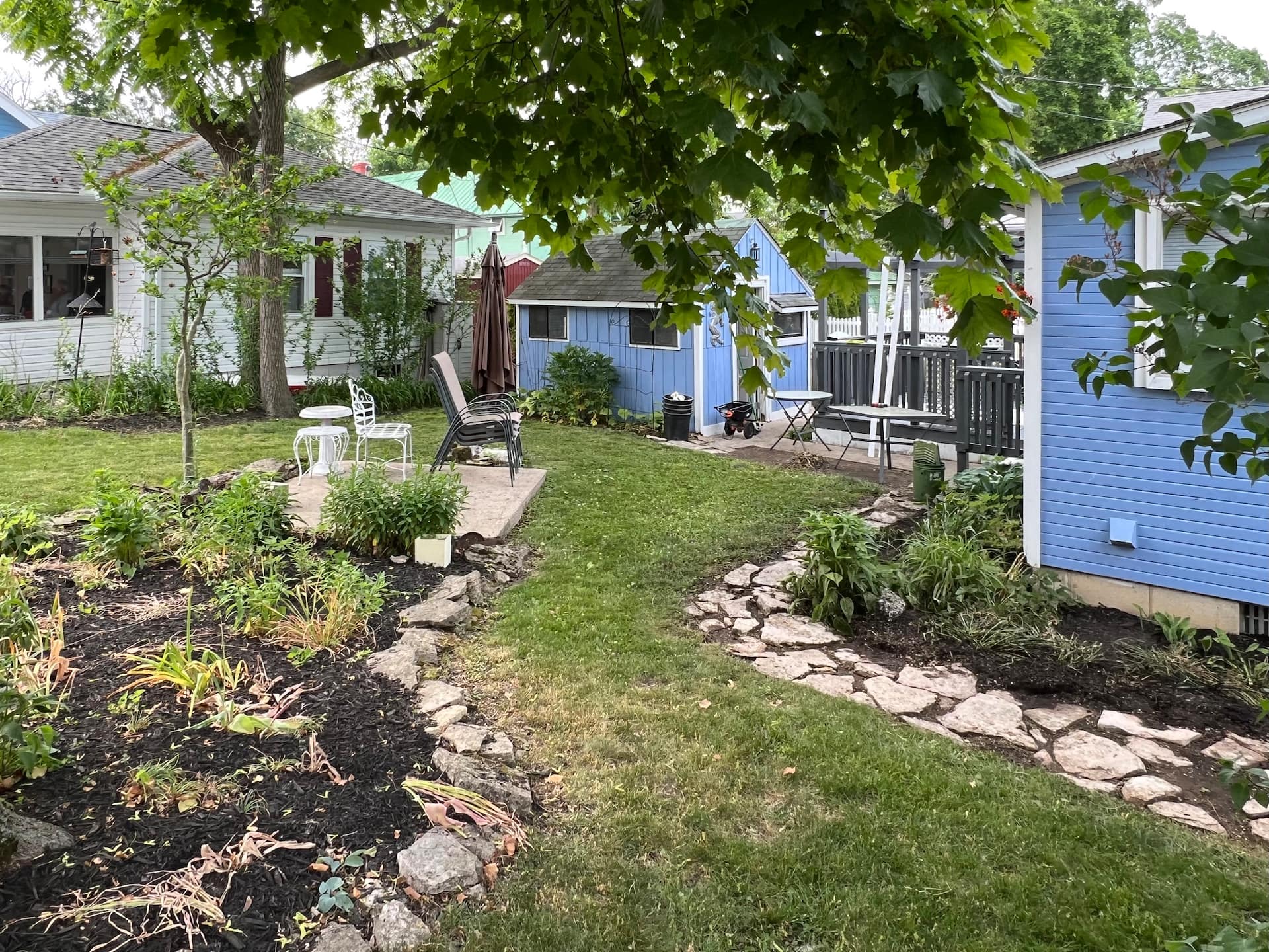 The front garden and stone border under mature trees
